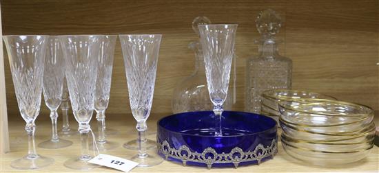 Ten cut glass champagne flutes, two decanters and a blue glass dish